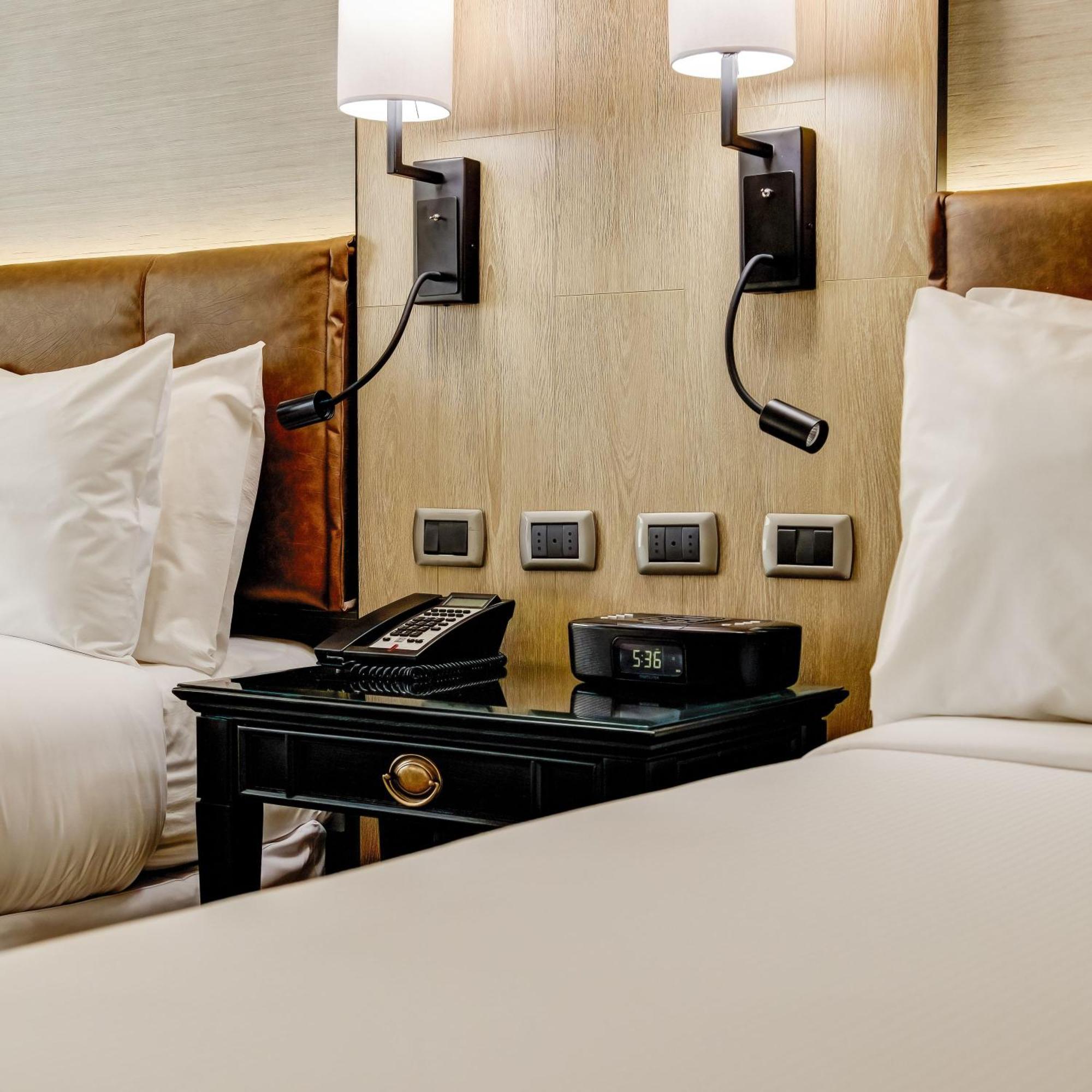 Plaza El Bosque Ebro Hotel Santiago Exterior foto A bedside table with a telephone and a digital alarm clock